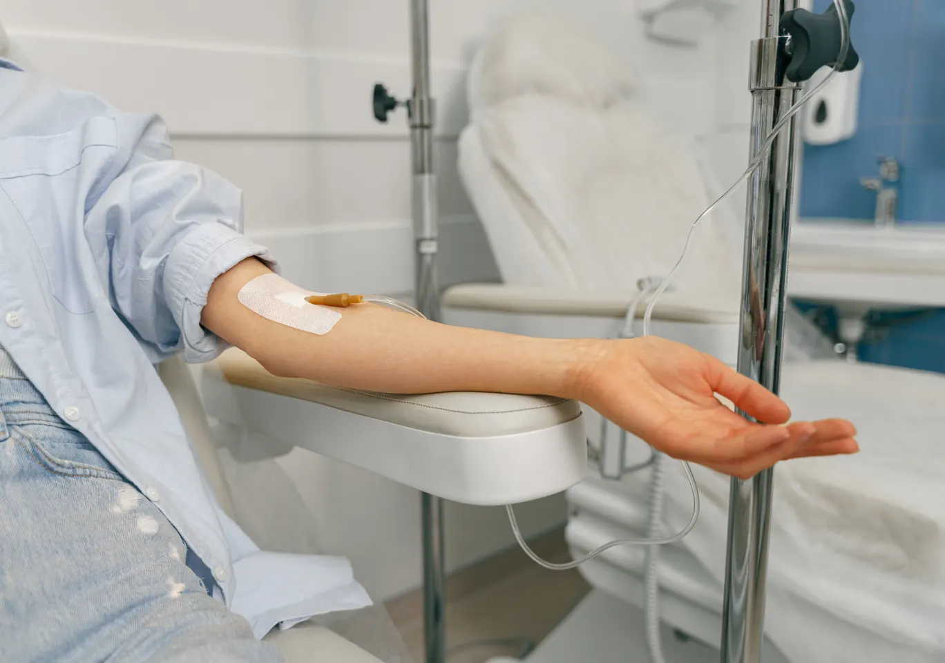 Kroplówki witaminowe Skoczów: przedramię z wenflonem i stojak infuzyjny obok